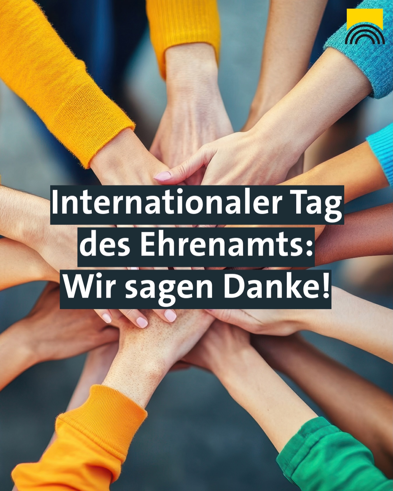 Dieser Alternativtext wurde KI-generiert: Ein Bild zeigt Hände übereinander, mit Text darüber. Der Text lautet: "Internationaler Tag des Ehrenamts: Wir sagen Danke!"