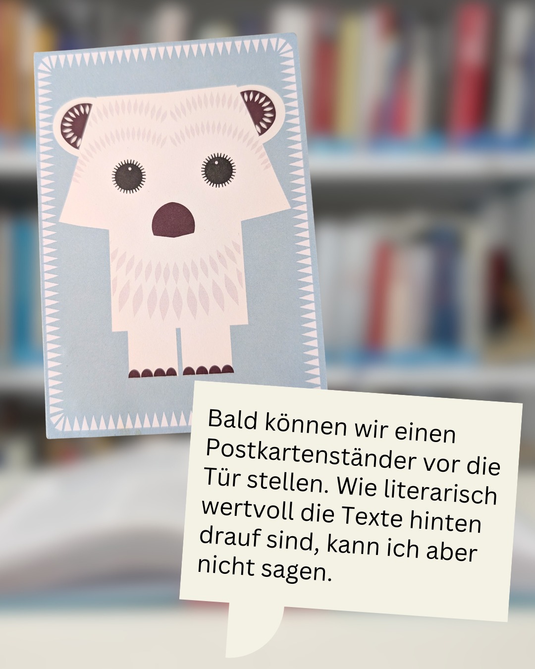 Dieser Alternativtext wurde KI-generiert: Ein hellblauer Kartenhalter mit einem Bärenmotiv steht vor Büchern. Ein Zettel mit Text ist daneben platziert.