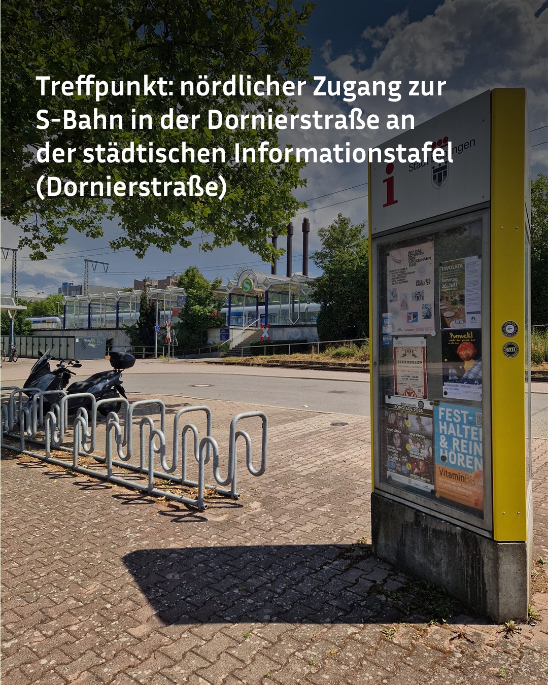 Rechts im Vordergrund steht eine gelbe städtische Informationstafel mit Plakaten, links daneben ein Fahrradständer mit einem geparkten Roller. Im Hintergrund ist der nördliche Zugang zur S-Bahn-Station mit einem blauen Zug und einem Glasdach zu sehen. Über dem Bild steht der weiße Text: „Treffpunkt: nördlicher Zugang zur S-Bahn in der Dornierstraße an der städtischen Informationstafel (Dornierstraße)“. (KI-Alternativtext)