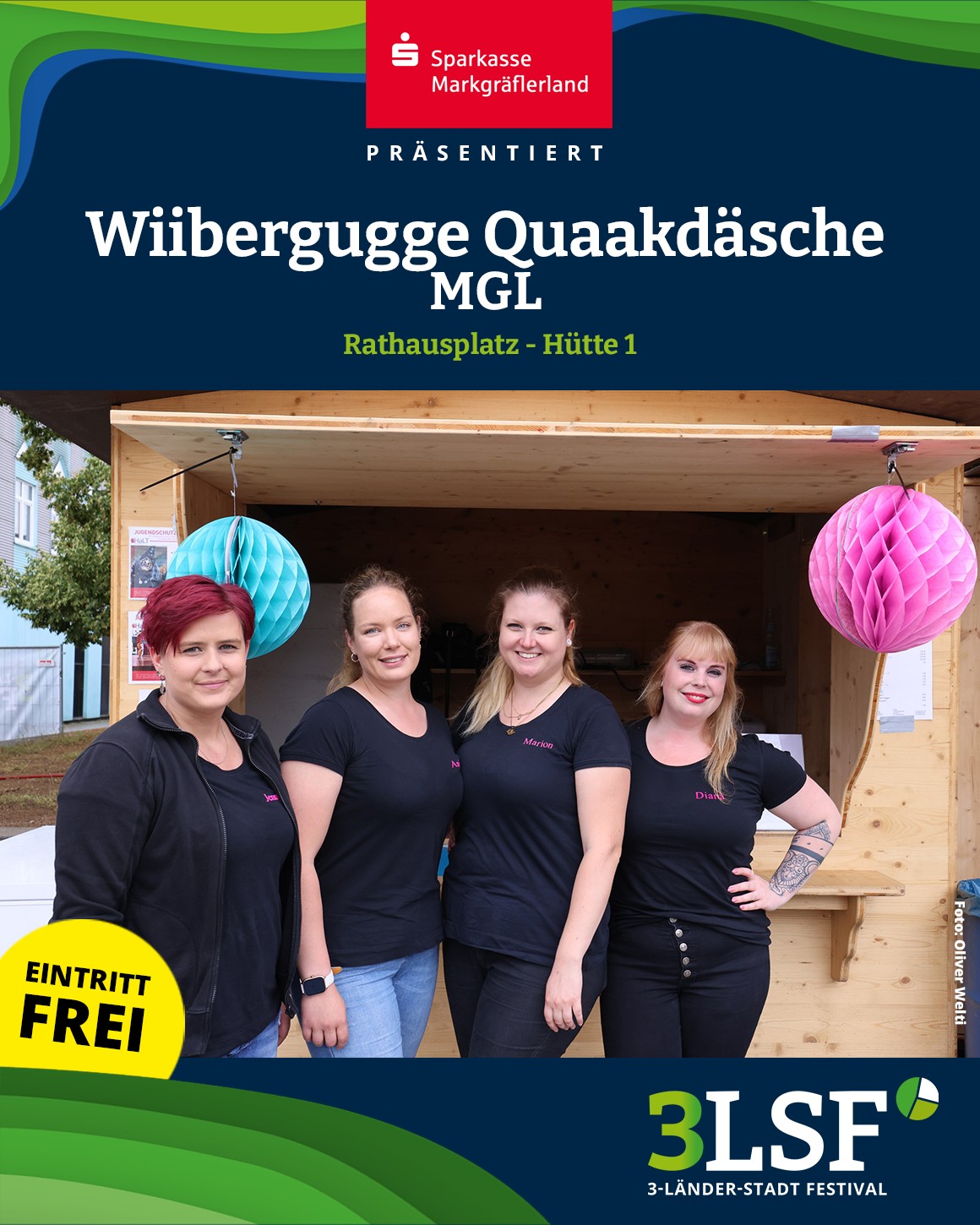Dieser Alternativtext wurde KI-generiert: Ein farbiges Bild zeigt eine Holzkonstruktion mit mehreren Personen davor. Im Hintergrund ist ein Gebäude und Dekorationen zu sehen.
