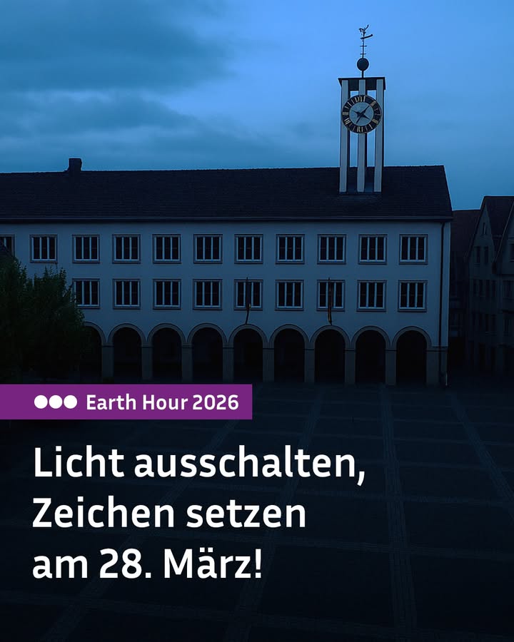 Dieser Alternativtext wurde KI-generiert: Ein dunkles Gebäude mit einem Uhrenturm ist gegen einen blauen Himmel abgebildet. Das Bild ist im Stil einer Schwarz-Weiß-Fotografie gehalten und enthält einen Textblock, der auf eine Aktion am 28. März hinweist.