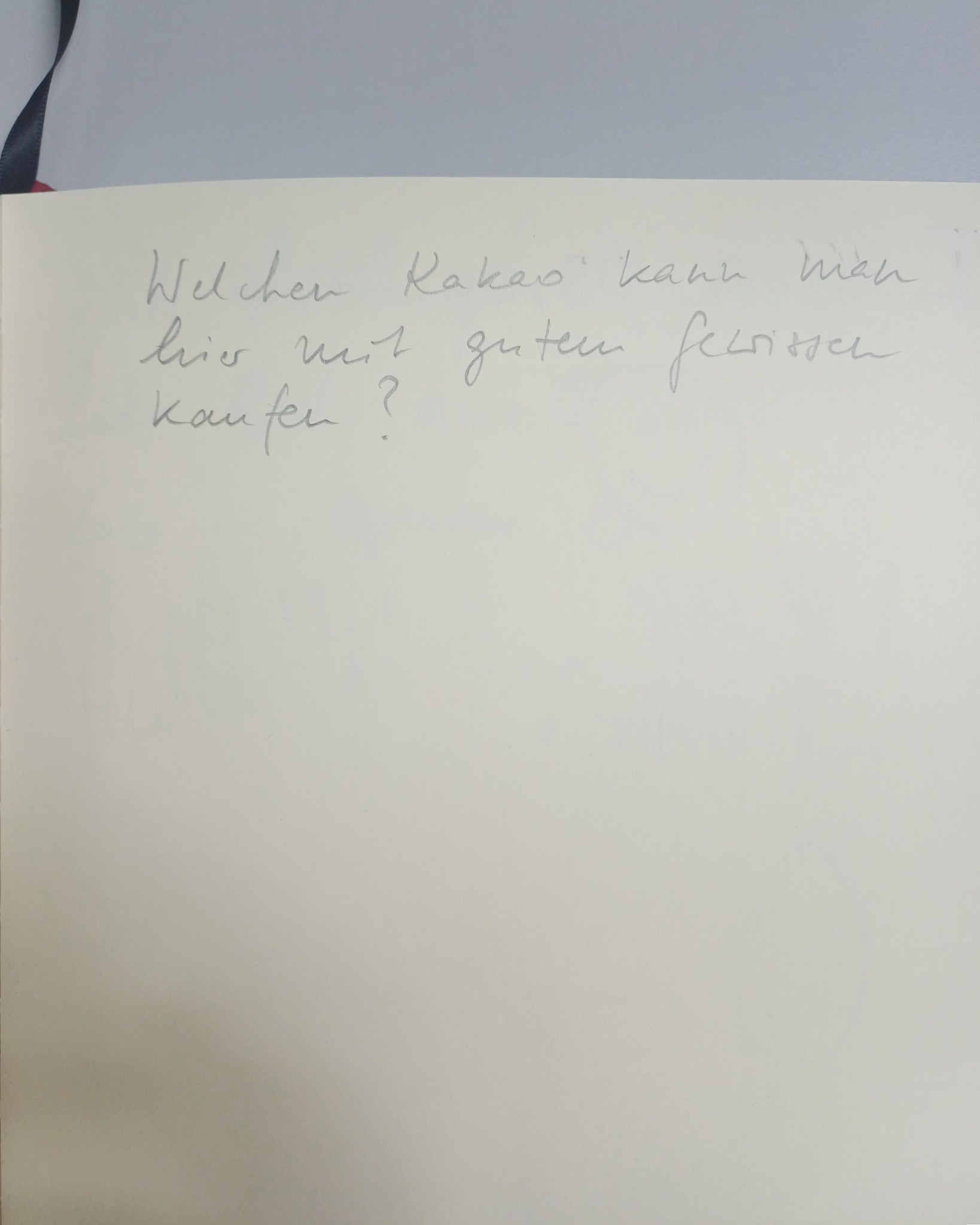Ein handschriftlicher Zettel auf weißem Papier mit der Frage: "Welchen Kakao kann man hier mit guten fechten kaufen?" (KI-Alternativtext)