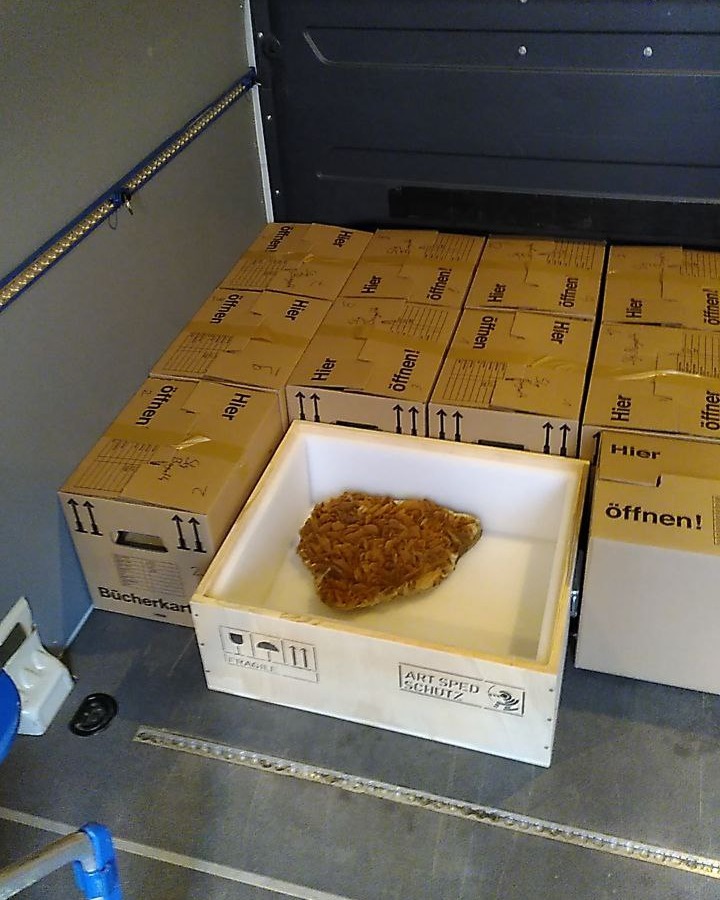 Dieser Alternativtext wurde KI-generiert: Mehrere Kartons sind gestapelt, mit Pfeilen und der Aufschrift "Öffnen!". Eine Schale mit braunem Inhalt steht auf einem weiteren Karton davor.