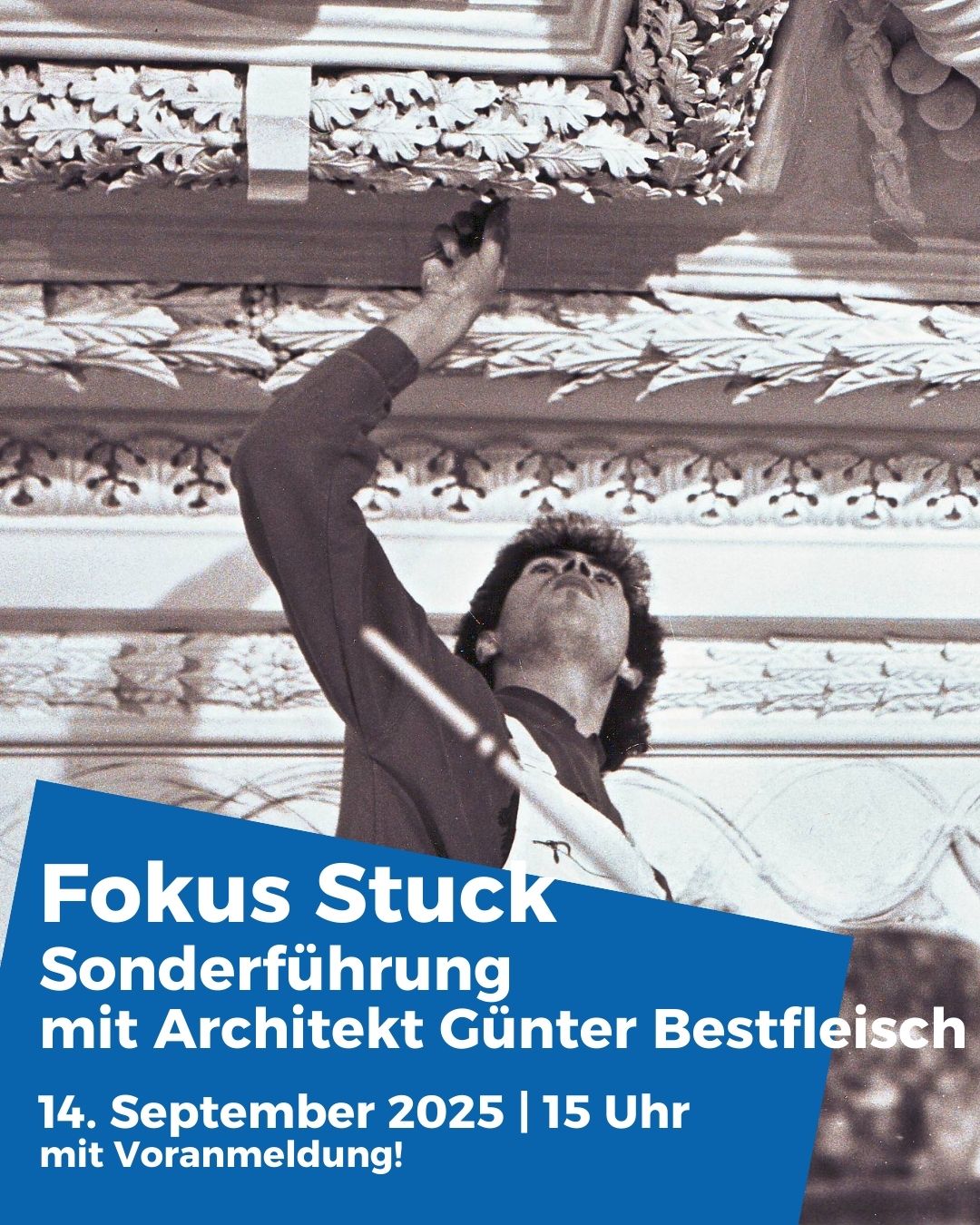 Dieser Alternativtext wurde KI-generiert: Schwarz-weißes Foto einer Person, die auf einer Bühne vor einer Zuschauermenge zu stehen scheint. Im Vordergrund befindet sich ein Werbeplakat für eine architektonische Sonderführung.