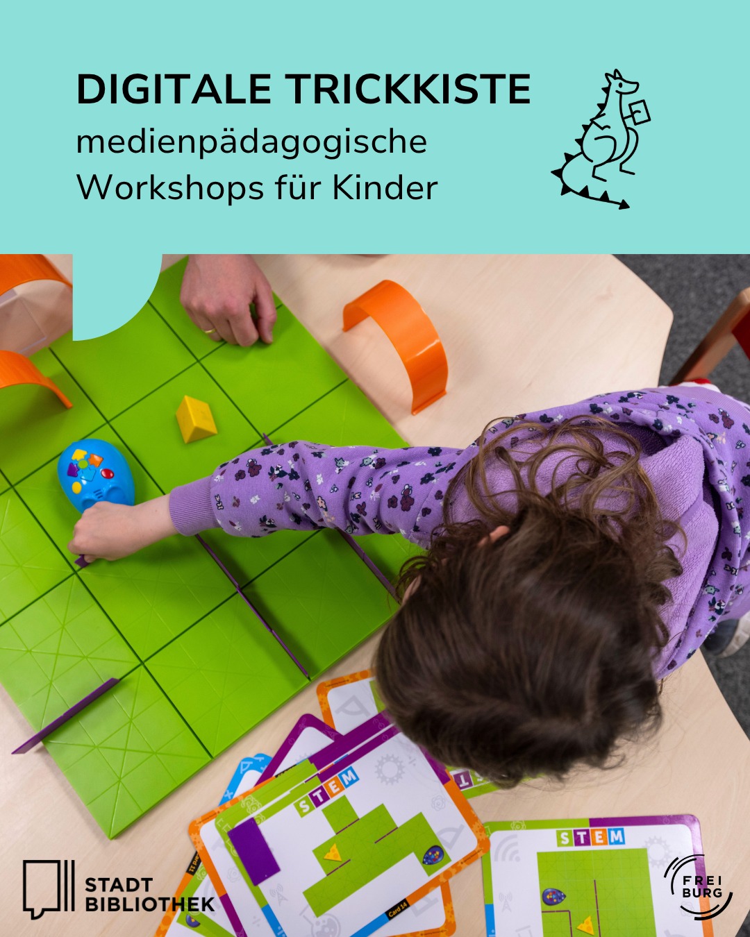 Oben steht auf hellblauem Grund der Text „DIGITALE TRICKKISTE medienpädagogische Workshops für Kinder“ neben einer Dinosaurier-Skizze. Darunter spielt eine Person an einem Tisch mit einem grünen Rasterbrett, einem blauen Roboter-Spielzeug und orangefarbenen Hindernissen. Im Vordergrund liegen Spielkarten mit der Aufschrift „STEM“ sowie die Logos der Stadtbibliothek und Freiburg. (KI-Alternativtext)