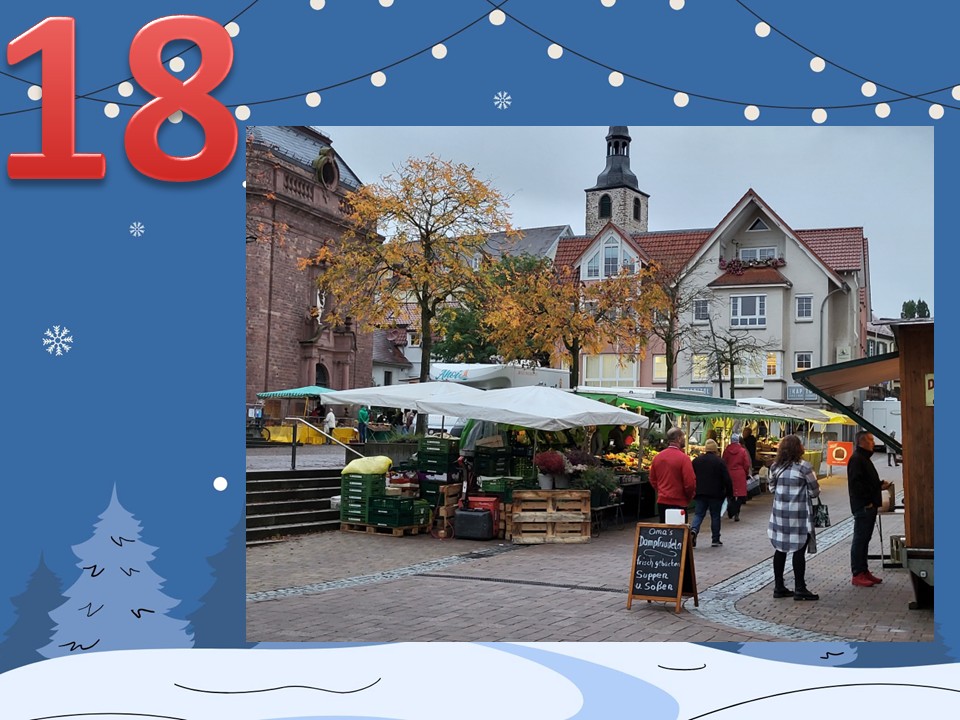Dieser Alternativtext wurde KI-generiert: Ein Stadtbild mit Marktplatz und Gebäuden im Hintergrund. Dekorative Elemente wie Schneeflocken und Lichterketten rahmen das Bild ein.