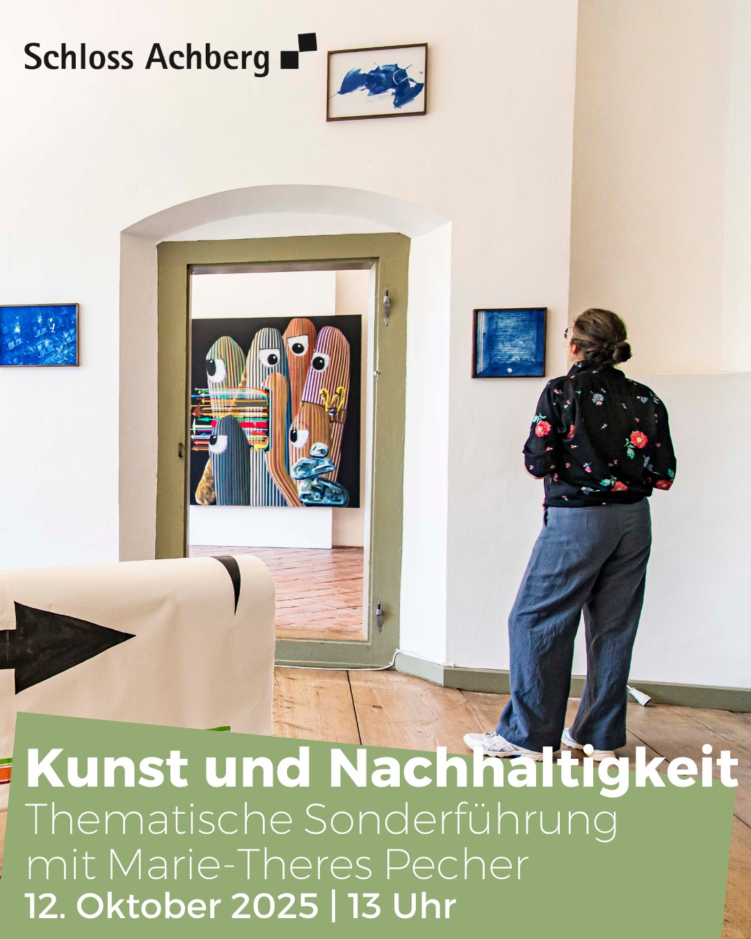 Dieser Alternativtext wurde KI-generiert: Ein Innenraum mit mehreren bunten Kunstwerken an den Wänden. Eine Person steht mit dem Rücken zum Betrachter vor den Werken und betrachtet sie.