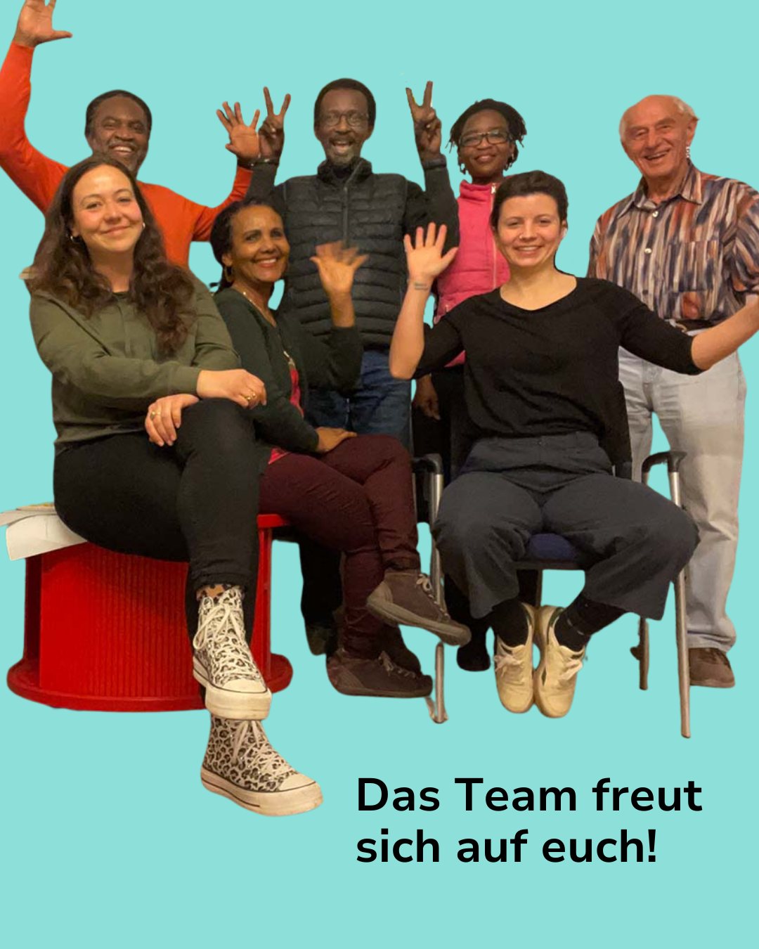 Dieser Alternativtext wurde KI-generiert: Eine Gruppe von Menschen posiert fröhlich für ein Foto und zeigt verschiedene Handzeichen. Der Hintergrund ist hellblau und die Stimmung ist positiv.