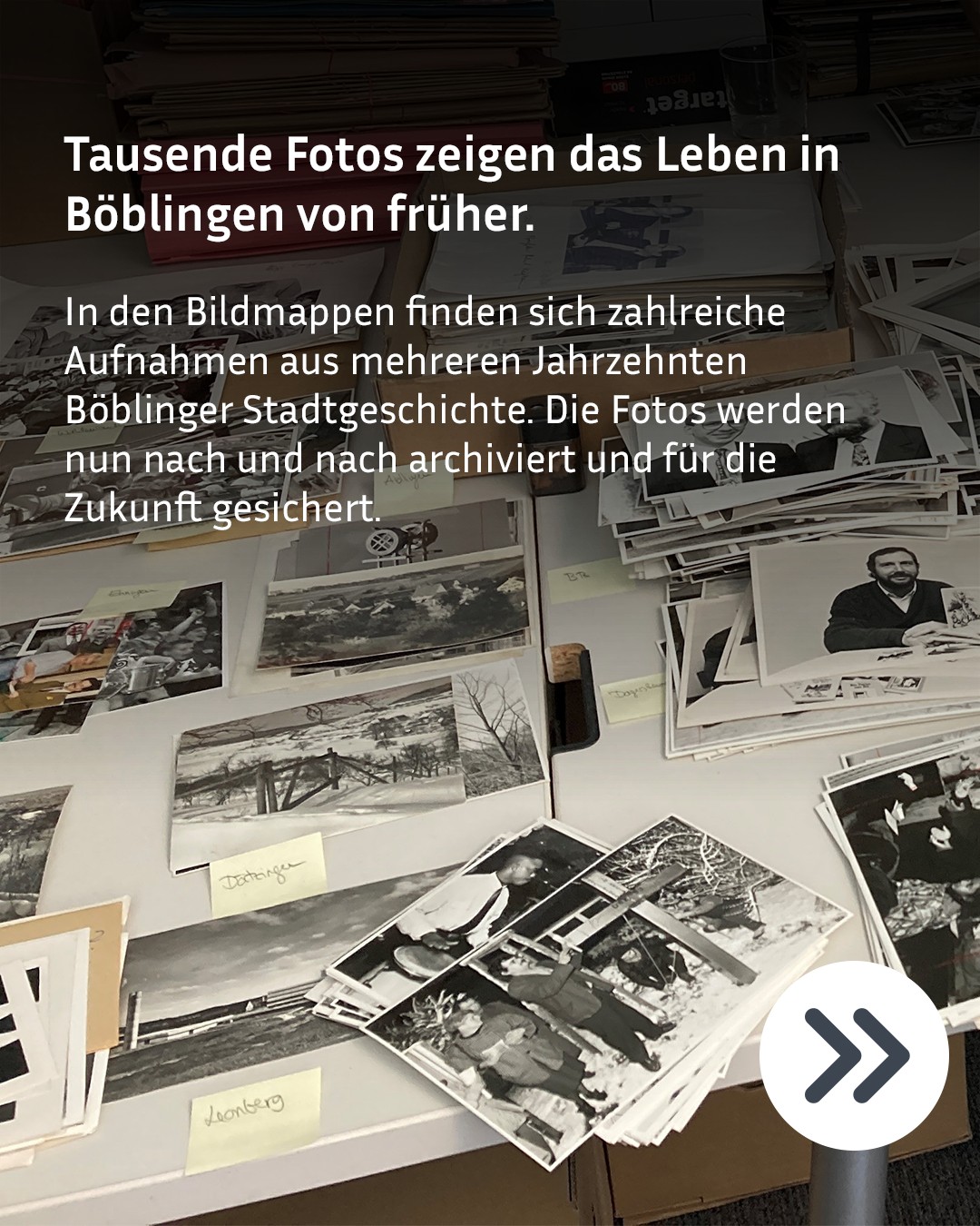 Tausende historische Schwarzweißfotos liegen auf einem Tisch verteilt und in Stapeln angeordnet. Gelbe Aufkleber kennzeichnen Orte wie Dottlingen und Leonberg. Der eingeblendete Text erklärt, dass diese Fotos aus mehreren Jahrzehnten der Böblinger Stadtgeschichte nun archiviert werden, um das Leben früherer Zeiten zu sichern. (KI-Alternativtext)