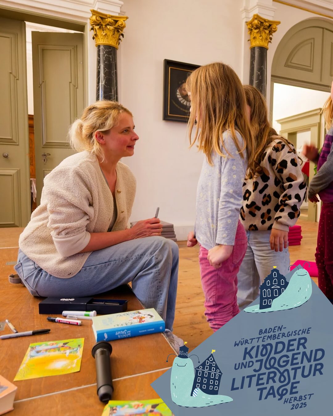 Dieser Alternativtext wurde KI-generiert: Eine Person sitzt auf dem Boden und zeigt ein Buch, während eine andere Person davor steht. Im Hintergrund ist eine Wand mit einer Tür zu sehen.