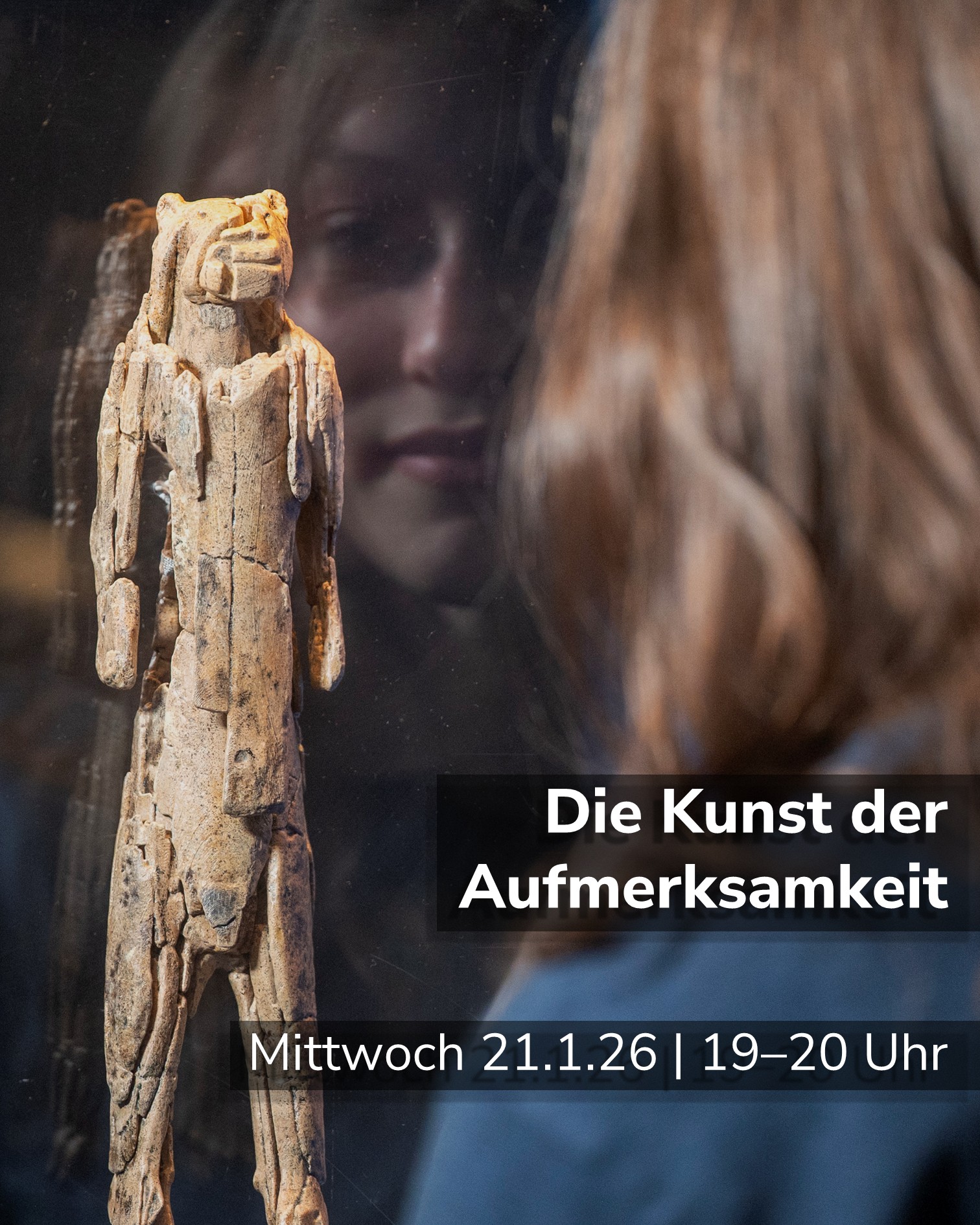 Dieser Alternativtext wurde KI-generiert: Ein schlichtes, steinernes Objekt steht im Vordergrund. Im Hintergrund ist ein verschwommener, farbiger Hintergrund und Text zu erkennen, der Informationen zu einer Veranstaltung enthält.