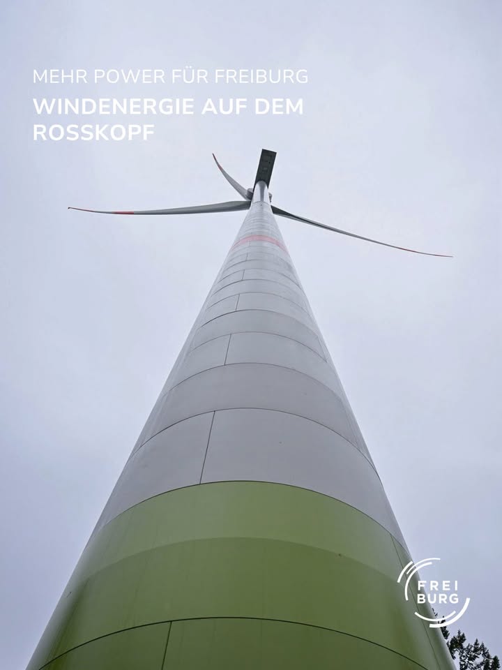 Dieser Alternativtext wurde KI-generiert: Eine Windkraftanlage ragt in den Himmel. Das Bild ist aus einem niedrigen Winkel aufgenommen und zeigt einen Großteil des Turms sowie die Rotorblätter.