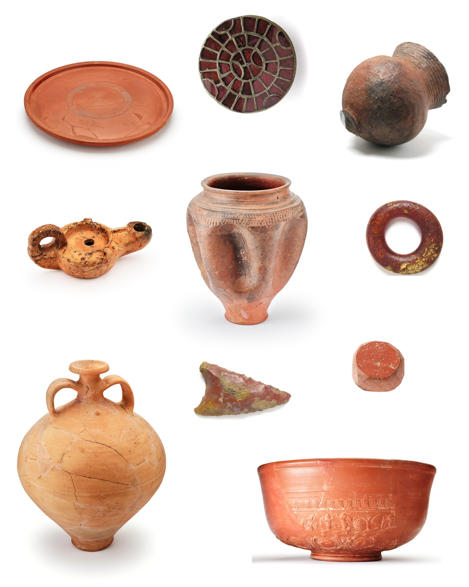 Verschiedene antike Keramikobjekte auf weißem Hintergrund. Dazu gehören eine flache Schale, eine Öllampe, eine zweihenklige Amphora, eine hohe Vase, ein Ring, ein gemustertes rundes Objekt und eine Schale mit Reliefs. (KI-Alternativtext)
