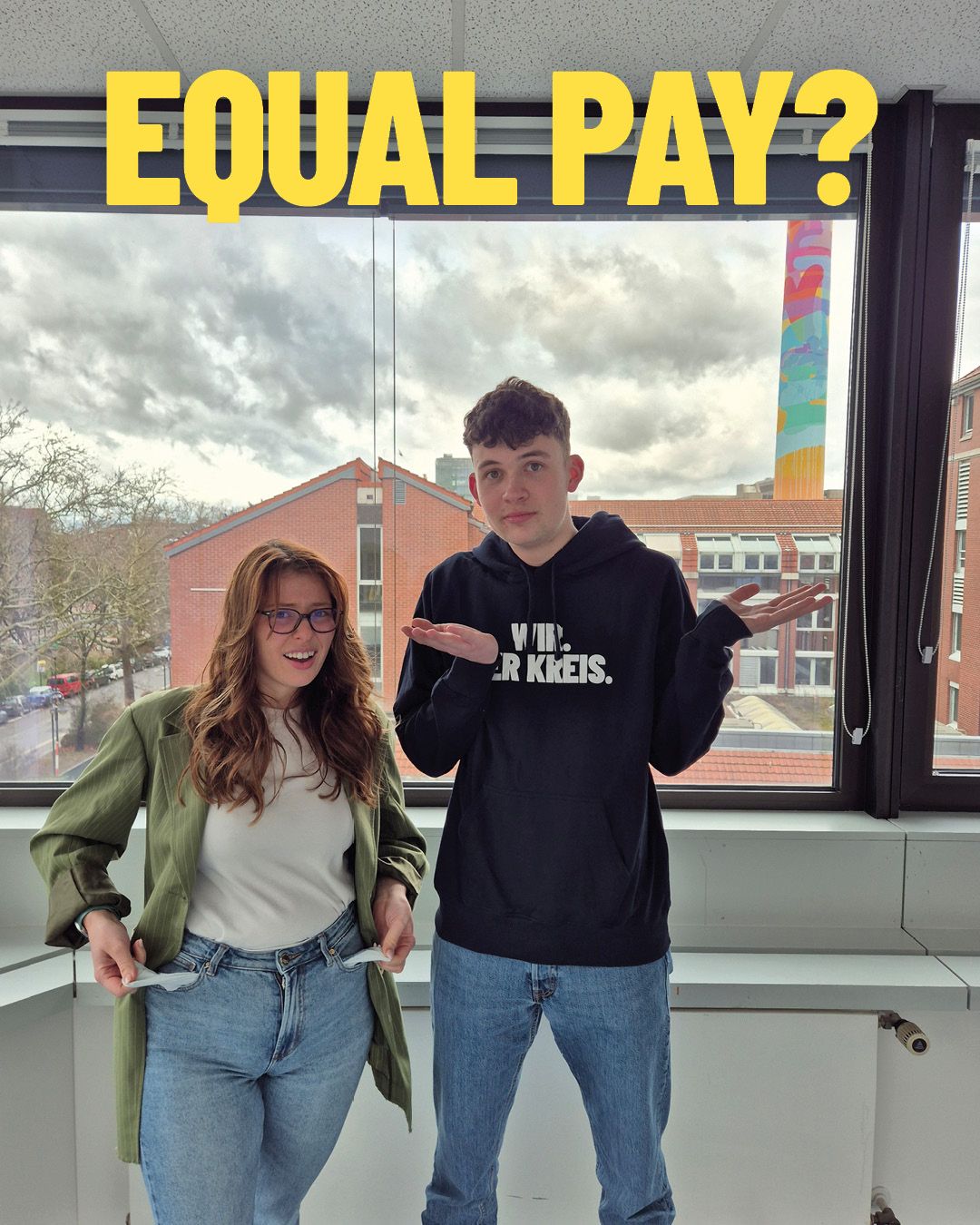 Dieser Alternativtext wurde KI-generiert: Zwei Personen stehen vor einem Fenster mit Blick auf eine Stadtlandschaft. Über ihren Köpfen steht in großen Buchstaben die Frage: "EQUAL PAY?"