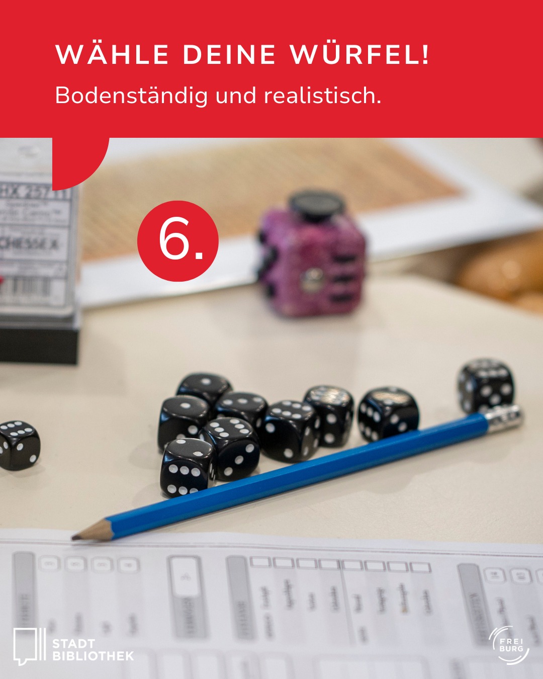 Dieser Alternativtext wurde KI-generiert: Ein Foto zeigt Spielwürfel, eine Bleistift und einen Radiergummi auf einem karierten Untergrund. Im Bild ist eine rote Zahl '6' zu sehen.
