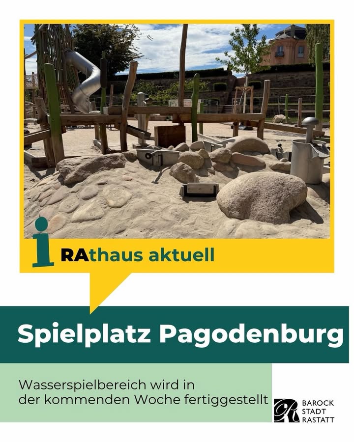 Spielplatz mit Sandbereich, Felsen, Holzkonstruktionen und Rutsche unter blauem Himmel. Unten Text: „Rathaus aktuell – Spielplatz Pagodenburg – Wasserspielbereich wird in der kommenden Woche fertiggestellt“ sowie Logo „Barock Stadt Rastatt“. (KI-Alternativtext)
