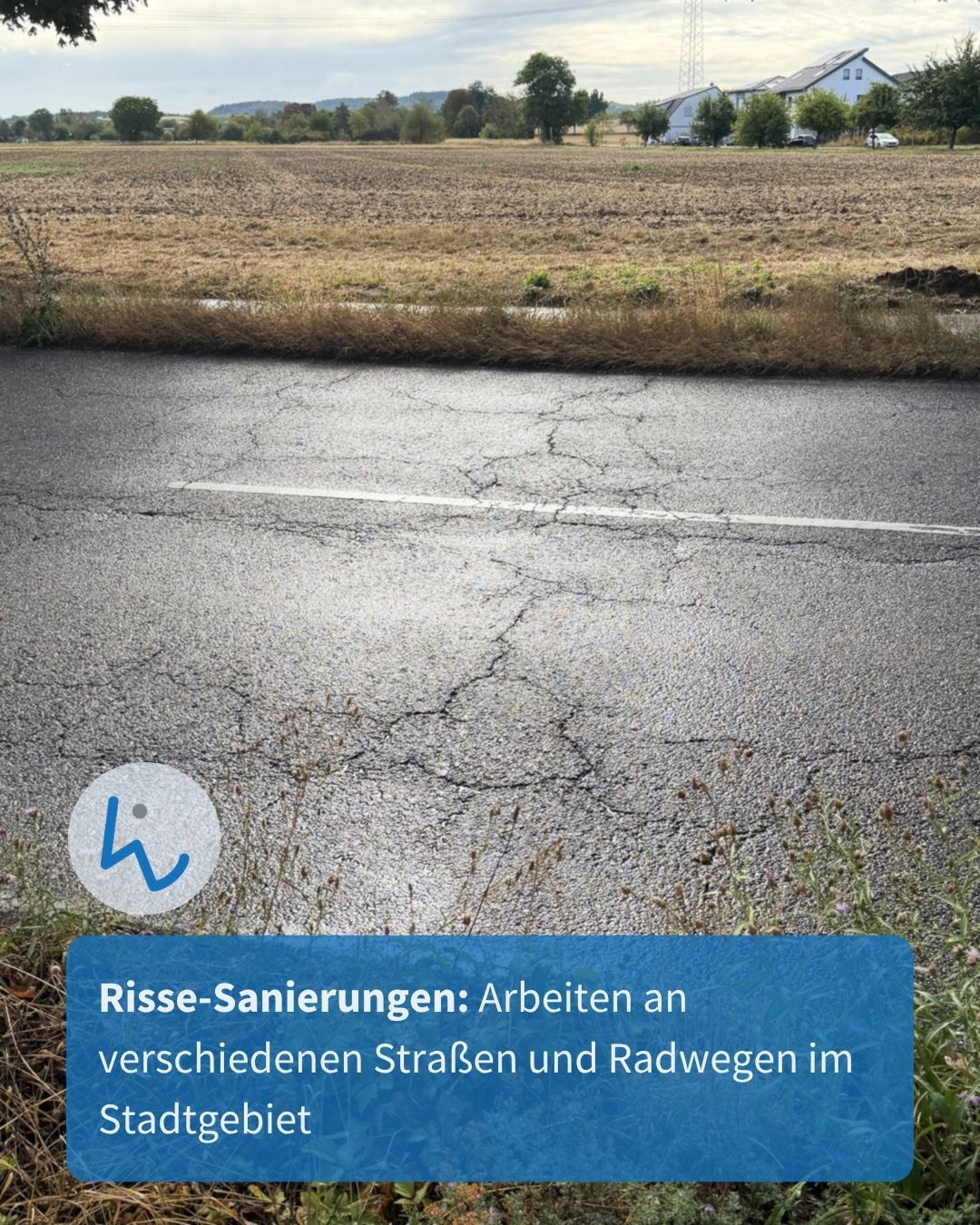 Asphaltstraße mit deutlichen Rissen und einer weißen Linie im Vordergrund, dahinter ein trockenes Feld und im Hintergrund ein Haus mit Solaranlage. Ein blauer Textkasten unten lautet: "Risse-Sanierungen: Arbeiten an verschiedenen Straßen und Radwegen im Stadtgebiet". (KI-Alternativtext)