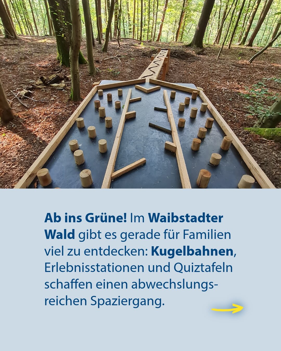 Eine große, aus Holz gebaute Kugelbahn mit schwarzer Oberfläche und vielen kleinen Holzstümpfen als Hindernisse liegt im Wald. Darunter steht auf hellblauem Hintergrund der Text: „Ab ins Grüne! Im Waibstadter Wald gibt es gerade für Familien viel zu entdecken: Kugelbahnen, Erlebnisstationen und Quiztafeln schaffen einen abwechslungsreichen Spaziergang.“ Rechts unten zeigt ein gelber Pfeil nach rechts. (KI-Alternativtext)