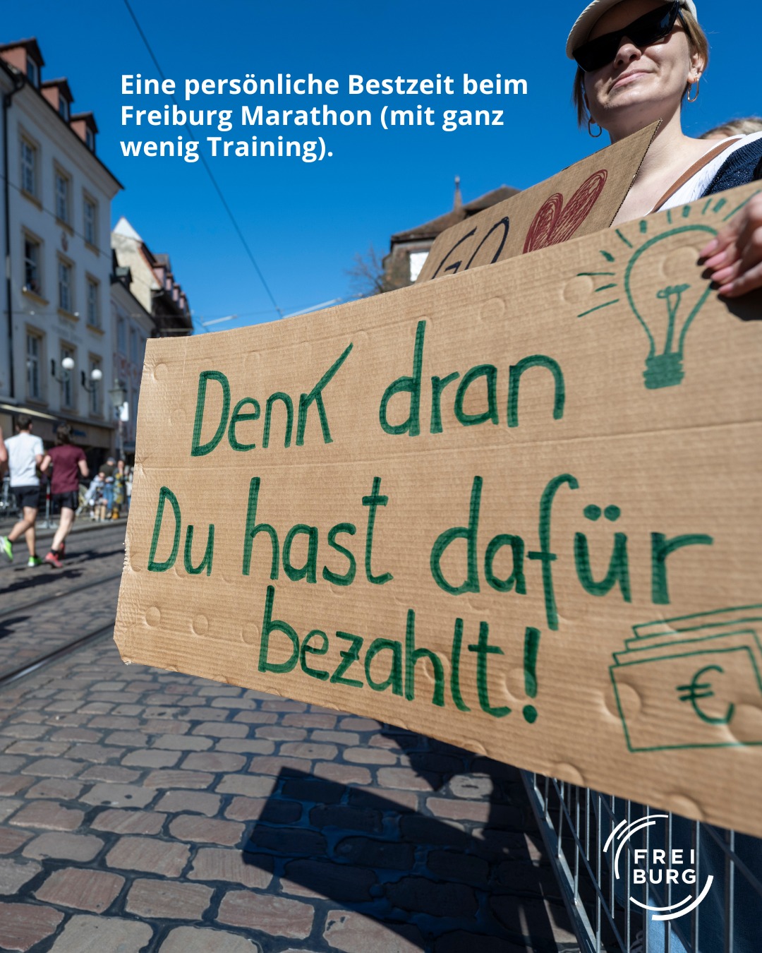 Dieser Alternativtext wurde KI-generiert: Ein Schild mit handschriftlichem Text ist im Vordergrund zu sehen. Es steht "Denk dran Du hast dafür bezahlt!" und ein Euro-Zeichen ist darauf zu erkennen.