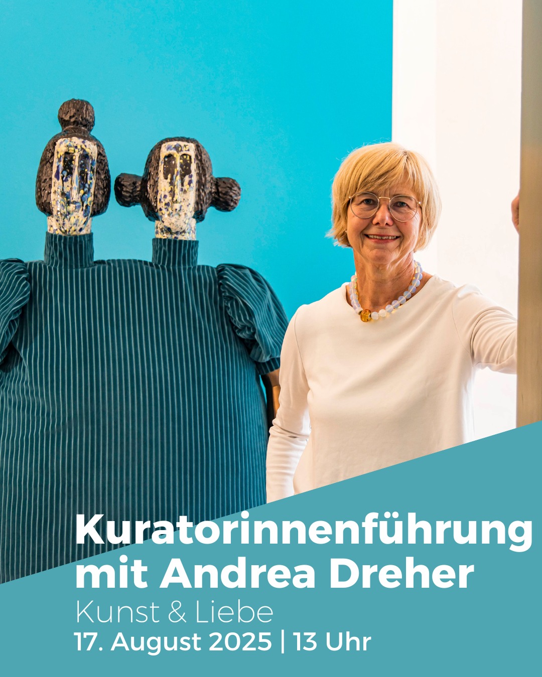 Eine Person steht neben einer Doppelbüste vor einem hellblauen Hintergrund. Im unteren Bereich ist Text zu sehen.