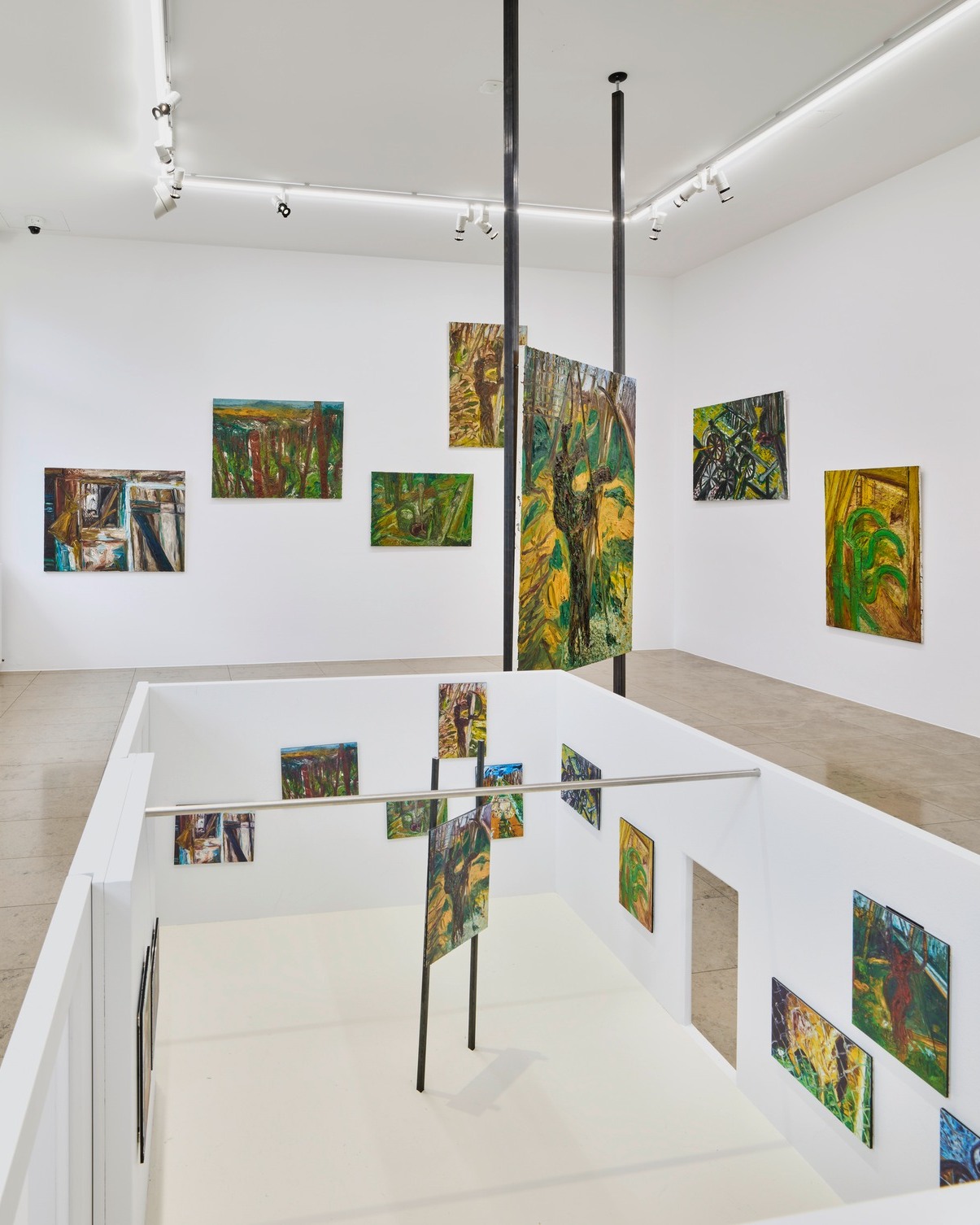 Dieser Alternativtext wurde KI-generiert: Ein heller Raum mit mehreren Wandbildern, die Landschaften darstellen. Spiegelungen erzeugen den Eindruck einer erweiterten Galerie, die verschiedene Kunstwerke zeigt.