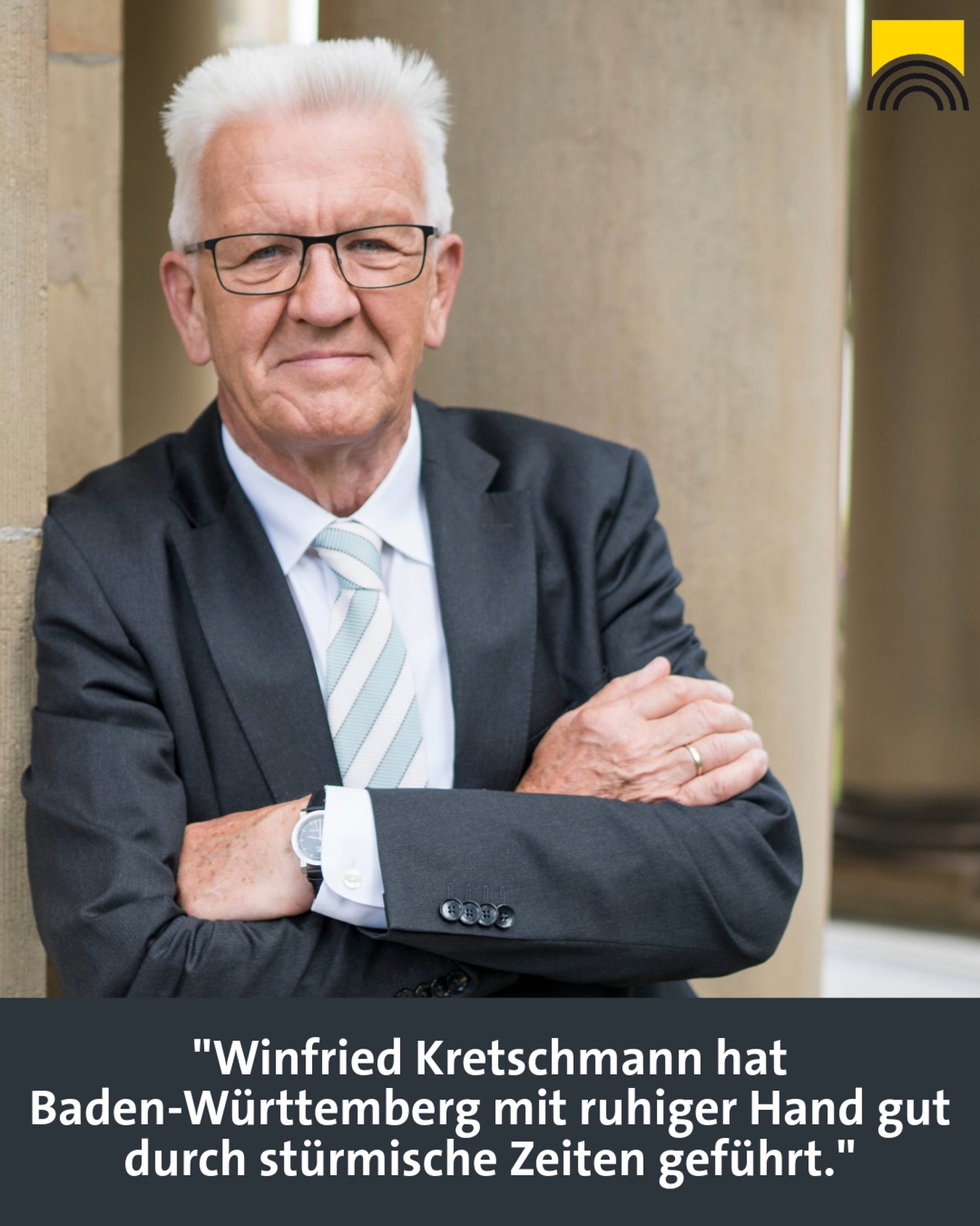 Dieser Alternativtext wurde KI-generiert: Schwarz-weißes Porträt einer Person mit Brille und Anzug, die vor einer hellen, strukturierten Wand steht. Unter dem Bild steht ein Textzitat.