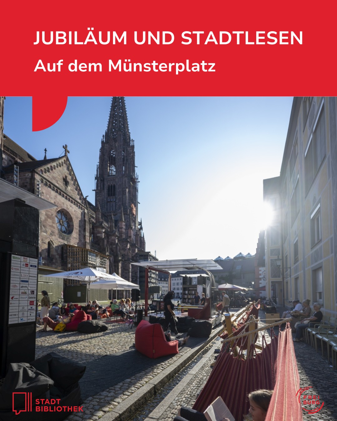 Jubiläumsveranstaltung „Stadtlesen“ auf dem Münsterplatz mit Leseecken, Hängematten und einem großen Kirchturm im Hintergrund. Menschen entspannen sich im Freien, einige lesen, andere sitzen unter Sonnenschirmen. Oben roter Balken mit weißem Text, unten Logos der Stadtbibliothek und Freiburg. (KI-Alternativtext)