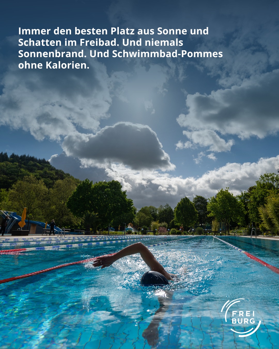 Dieser Alternativtext wurde KI-generiert: Ein farbiges Bild zeigt einen Swimmingpool im Freien mit einer Person beim Schwimmen. Im Hintergrund sind Bäume und ein bewölkter Himmel zu sehen.