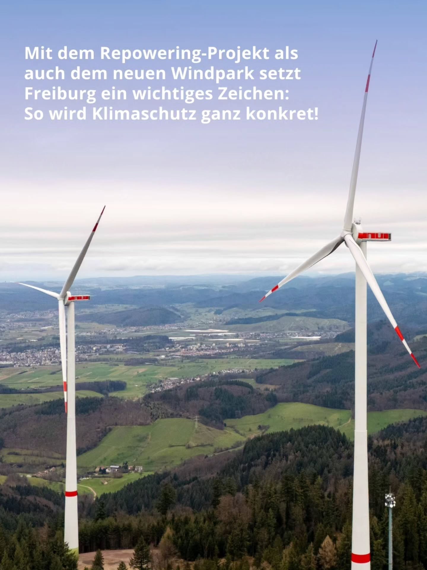 Dieser Alternativtext wurde KI-generiert: Ein farbiges Bild zeigt mehrere Windkraftanlagen vor einem Hügellandschafts- und Stadtpanorama. Die Anlagen dominieren das Bild und stehen für erneuerbare Energien.