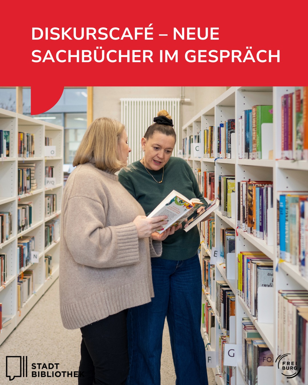Dieser Alternativtext wurde KI-generiert: Zwei Personen betrachten gemeinsam Bücher in einer Bibliothek. Im Hintergrund sind Regale voller Bücher zu sehen.