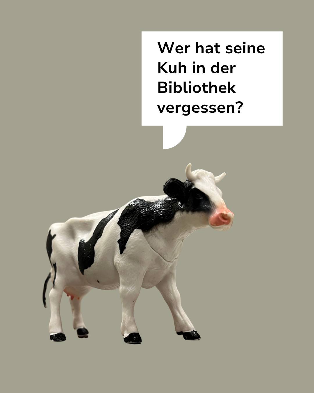 Eine schwarze und weiße Plastikkuh steht vor einem einfarbigen Hintergrund. Über dem Tier befindet sich eine Sprechblase mit der Frage: „Wer hat seine Kuh in der Bibliothek vergessen?“ (KI-Alternativtext)