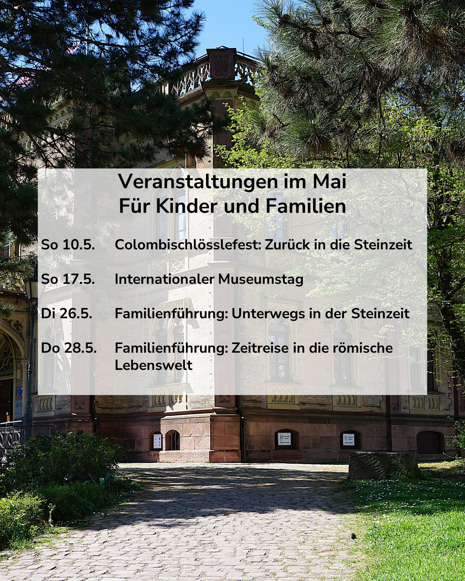 Dieser Alternativtext wurde KI-generiert: Ein farbiges Foto zeigt eine Veranstaltungshinweistafel vor einem historischen Gebäude mit roter Fassade und einem Turm. Die Tafel bewirbt Mai-Veranstaltungen für Kinder und Familien.