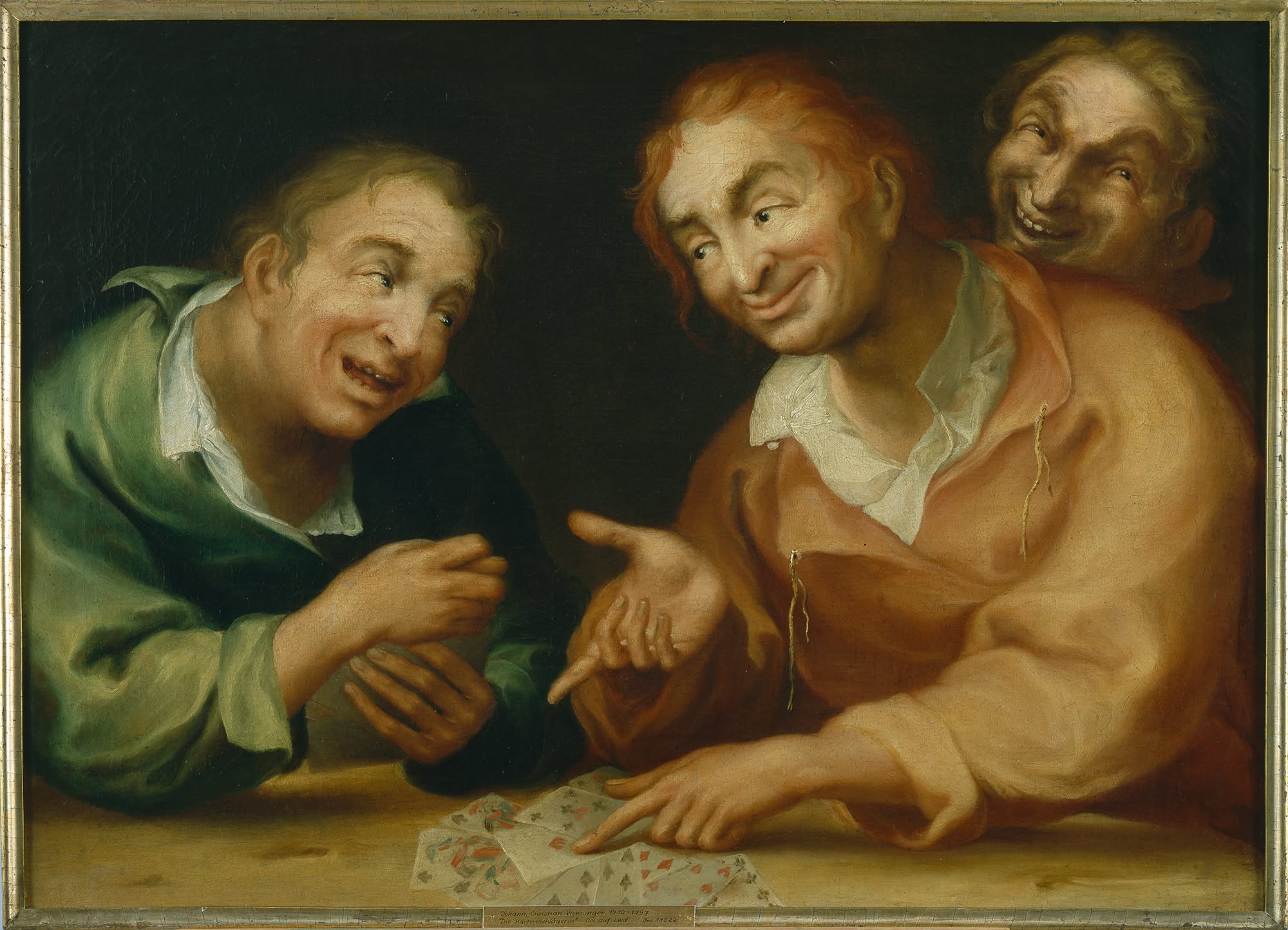 Drei Personen in historischer Kleidung sitzen an einem Tisch und blicken auf verstreute Spielkarten. Eine Person in rötlicher Kleidung zeigt auf die Karten, während alle drei lachen. Ein Schild am unteren Rand trägt die Aufschrift „Die Kartenschlägerin“. (KI-Alternativtext)