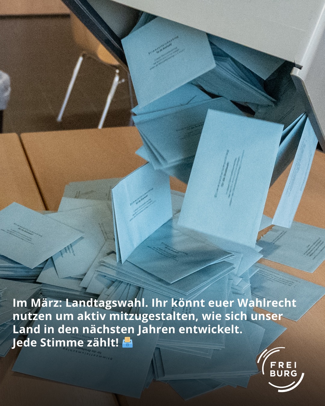 Dieser Alternativtext wurde KI-generiert: Ein Stapel Papiere liegt auf einer Holzoberfläche. Im Vordergrund befindet sich ein Text, der zur Wahl aufruft.