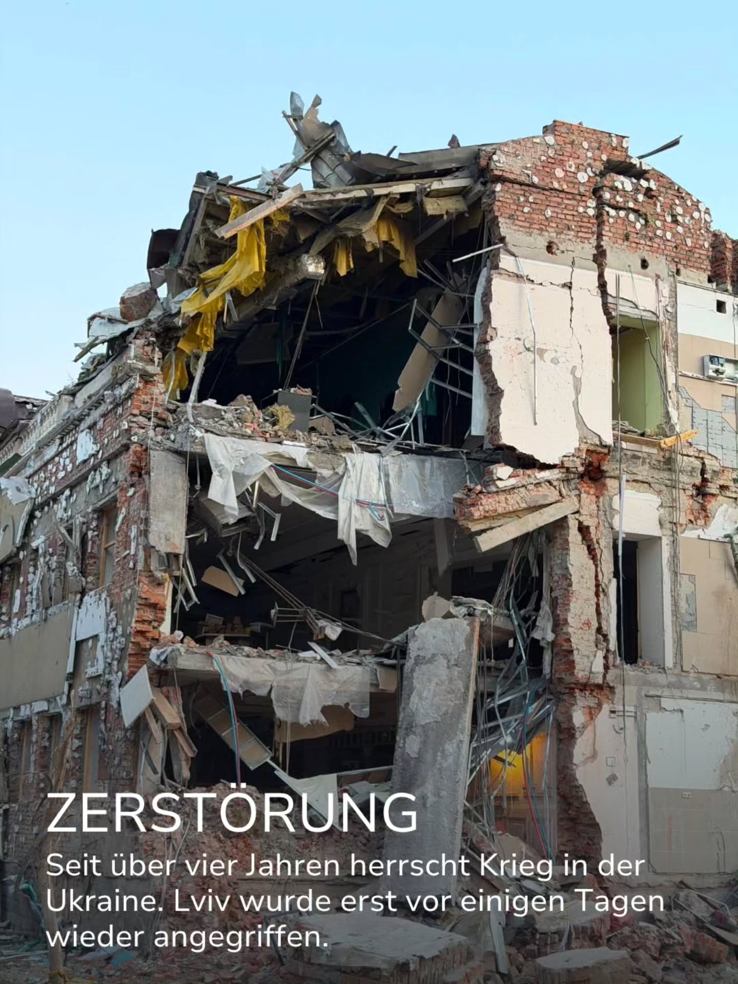 Stark beschädigtes Gebäude mit freiliegenden Ziegelwänden, Trümmern und hängenden Planen. Der weiße Text "ZERSTÖRUNG" überlagert das Bild, gefolgt von dem Satz: "Seit über vier Jahren herrscht Krieg in der Ukraine. Lviv wurde erst vor einigen Tagen wieder angegriffen." (KI-Alternativtext)